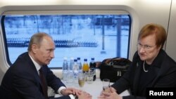 Vlagyimir Putyin orosz elnök és Tarja Halonen finn miniszterelnök egy vonaton 2010. december 10-én