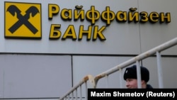 A Russian police officer stands in front of a Raiffeisen branch in Moscow. (file photo)