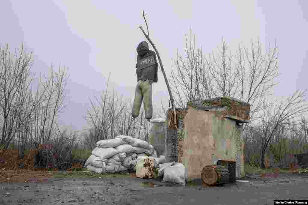 A dummy dressed as a Russian fighter hangs outside the village of Barvinkove on April 12. An obscene insult is written on the signboard.&nbsp;