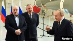 Președintele bielorus Alexander Lukașenka, directorul general al agenției Roscosmos Dmitri Rogozin și președintele rus Vladimir Putin la secția de asamblare a rachetelor de la cosmodromul Vostocini, regiunea Amur, Rusia, 12 aprilie 2022