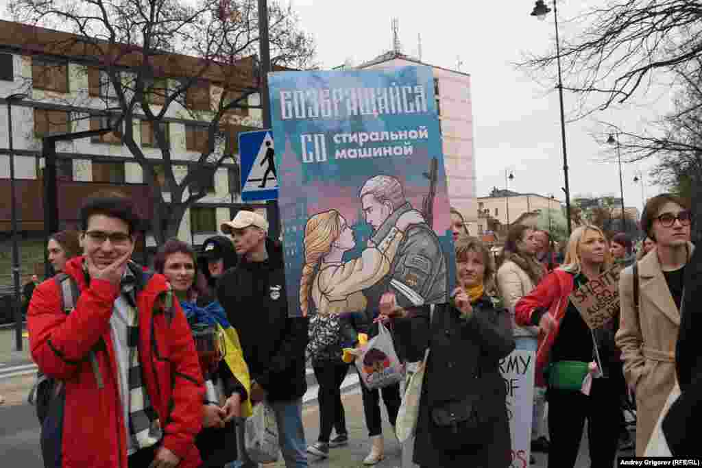 An illustrated placard with the words &quot;Come back with a washing machine,&quot; humorously alluding to alleged looting by Russian troops in Ukraine.&nbsp;