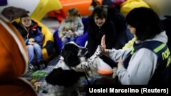 Ukrán gyerekek kutyaterápián Zaporizzsjában 2022. április 13-án