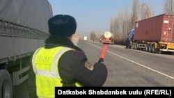 Ош-Эркештам жолунда турган жол коопсуздук кызматкери. 2025-жыл 