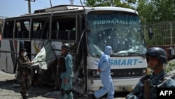 Afghan police and security personnel inspect the scene of a suicide attack on a bus that was transporting employees of the attorney general's office in Kabul, May 4, 2015