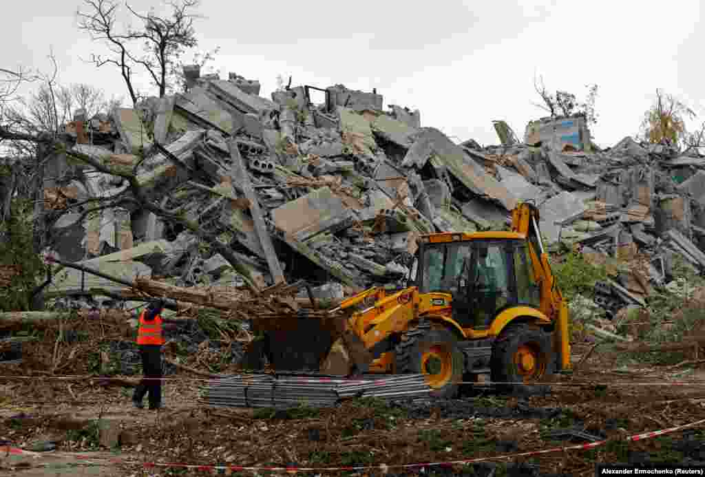 Muncitorii&nbsp;degajează resturile unui bloc de apartamente din Mariupol, pe 9 noiembrie. Potrivit unui oficial ucrainean, cadavrele a 200 de persoane au fost găsite în subsolul unui bloc de apartamente prăbușit în Mariupol. Mulți oameni au locuit în subsoluri în timpul asediului pentru a se adăposti de schije și gloanțe.