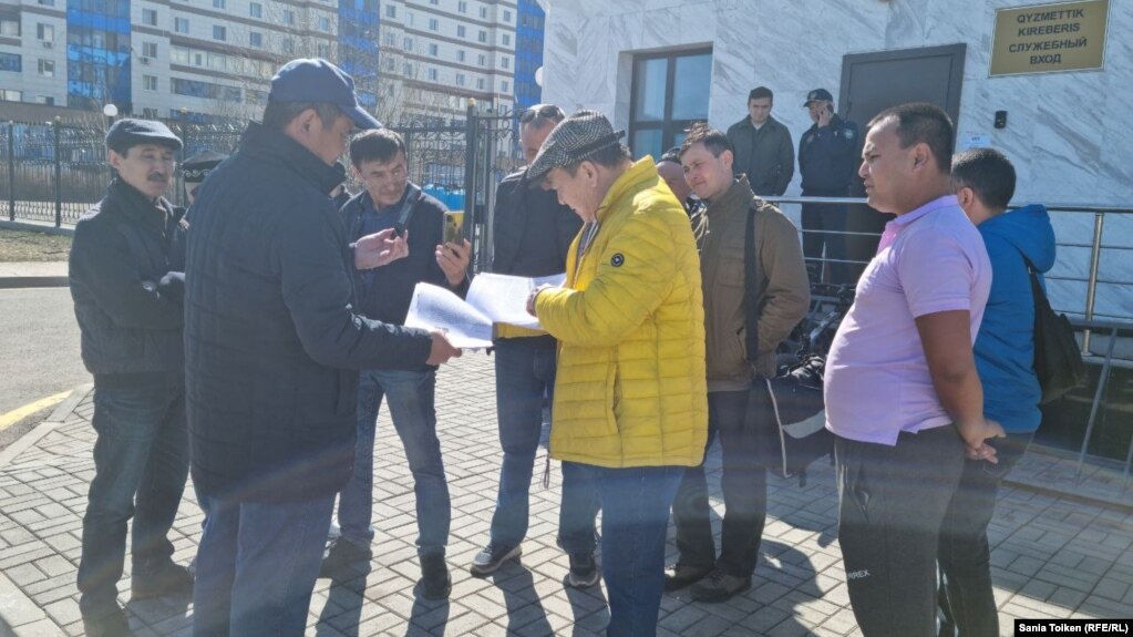 Активист Жанат Нуркишев (в центре) перед зданием Генеральной прокуратуры Казахстана. Нур-Султан, 14 апреля 2022 года