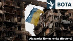Flamuri ukrainas i varur në një ndërtesë të shkatërruar në Mariupol në fillim të luftës.