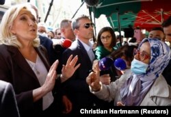 Marine Le Pen, kandidatkinja francuske krajnje desničarske stranke na francuskim predsjedničkim izborima 2022., razgovara sa ženom s maramom tokom posjeta tržnici dok vodi kampanju u Pertuisu, blizu Marseillea na jugu Francuske.