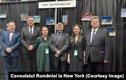 Șase oficiali s-au înghesuit într-o poză de grup în fața panoului negru pe care au fost agățate câteva fotografii cu atracțiile turistice ale României, la Târgul Internațional de Turism „The Travel & Adventure Show” din New York, 19-20 martie 2022.