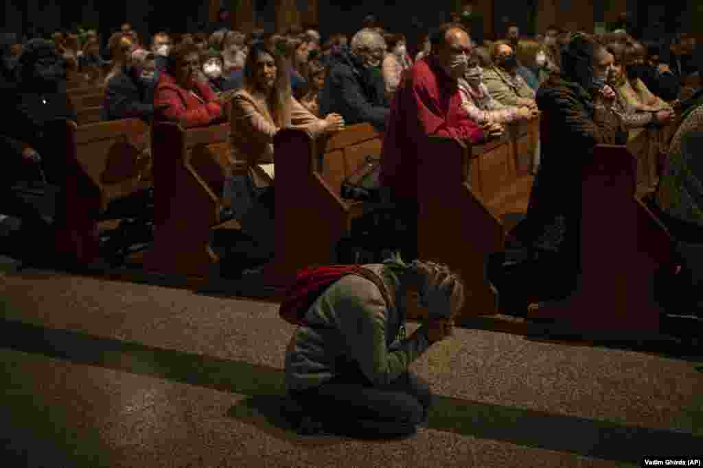 A woman prays in an aisle during the Maundy Thursday service at the St. Joseph Cathedral in Bucharest, Romania, on April 14.&nbsp;
