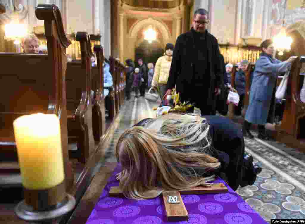A Roman Catholic woman kisses a crucifix during the Holy Saturday service at the Cathedral of the Assumption of the Blessed Virgin in the western Ukrainian city of Lviv on April 16.&nbsp;Ukraine&#39;s Catholic worshipers celebrate Easter a week before the country&#39;s Orthodox majority.