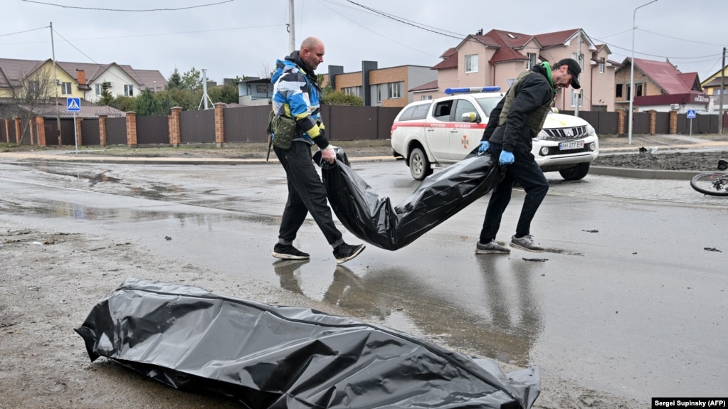Communal workers carry body bags in the town of Bucha on April 3.