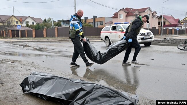 Communal workers carry body bags in the town of Bucha on April 3.