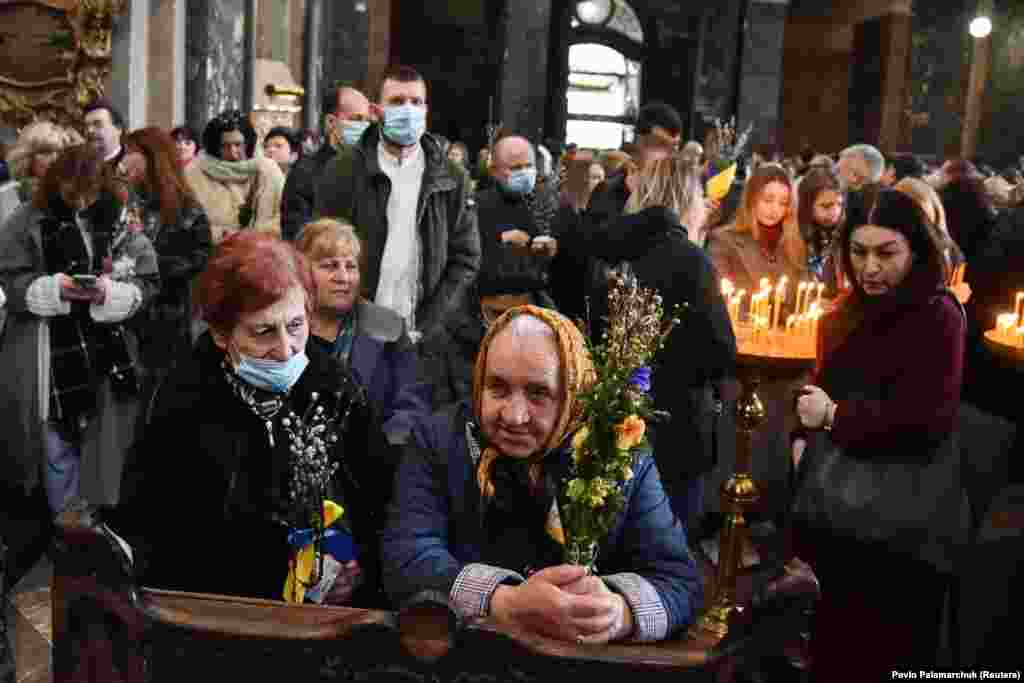 People attend the consecration of willow branches on Palm Sunday in Lviv on April 17.