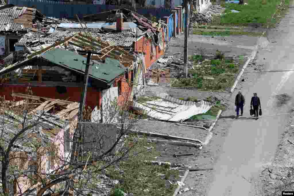 Više od 400.000 ljudi živjelo je u Mariupolju prije ruske invazije, a najmanje 140.000 uspjelo je pobjeći iz grada. (na fotografiji: ljudi prolaze pored uništenih objekata u Mariupolju, 18. april.)