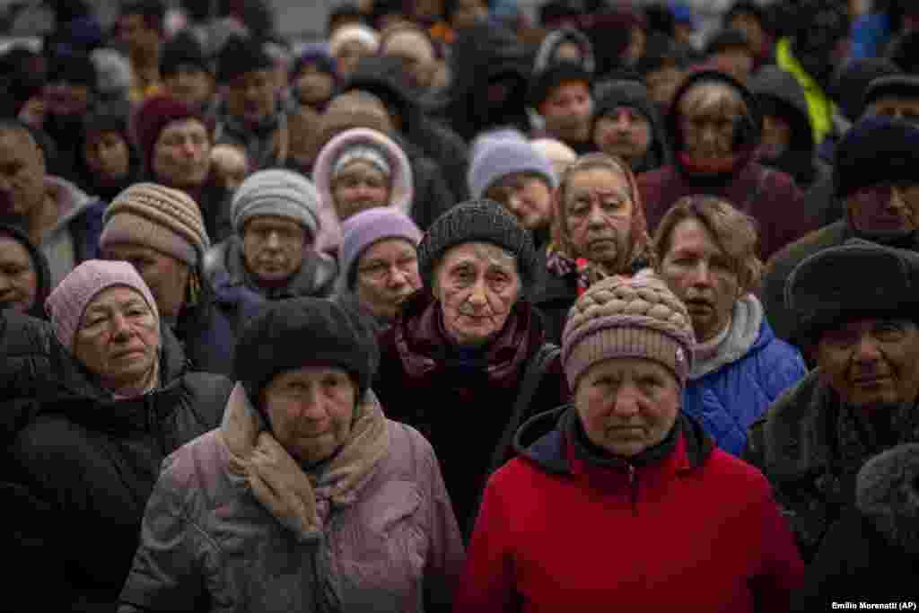Ukrainians wait for food during a distribution organized by the Red Cross in Bucha, on the outskirts of Kyiv.