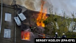 Пожежники гасять вогонь у житловому будинку в Харкові після обстрілу міста з боку військ РФ, 17 квітня 2022 року