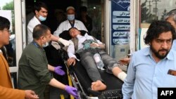 Medical staff move an injured boy after blasts rocked a high school in Kabul on April 19.
