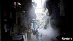 Autoritetet shëndetësore duke dezinfektuar një qytet në Kinë.