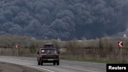 Авто проїжджає повз Лисичанський НПЗ після влучання ракети, Лисичанськ, Луганська область, 16 квітня 2022 року