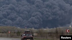 Авто проезжает мимо Лисичанского НПЗ после попадания ракеты, Лисичанск, Луганская область, 16 апреля 2022 года