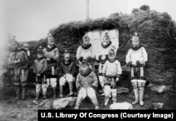 Greenlandic Inuit women photographed outside their turf house in the late 1800s