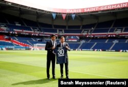 Lionel Messi și președintele clubului de fotbal Paris Saint Germain, Nasser Al-Khelaifi, la prezentarea fotbalistului argentinian pe stadionul Parc des Princes, 11 august 2021.