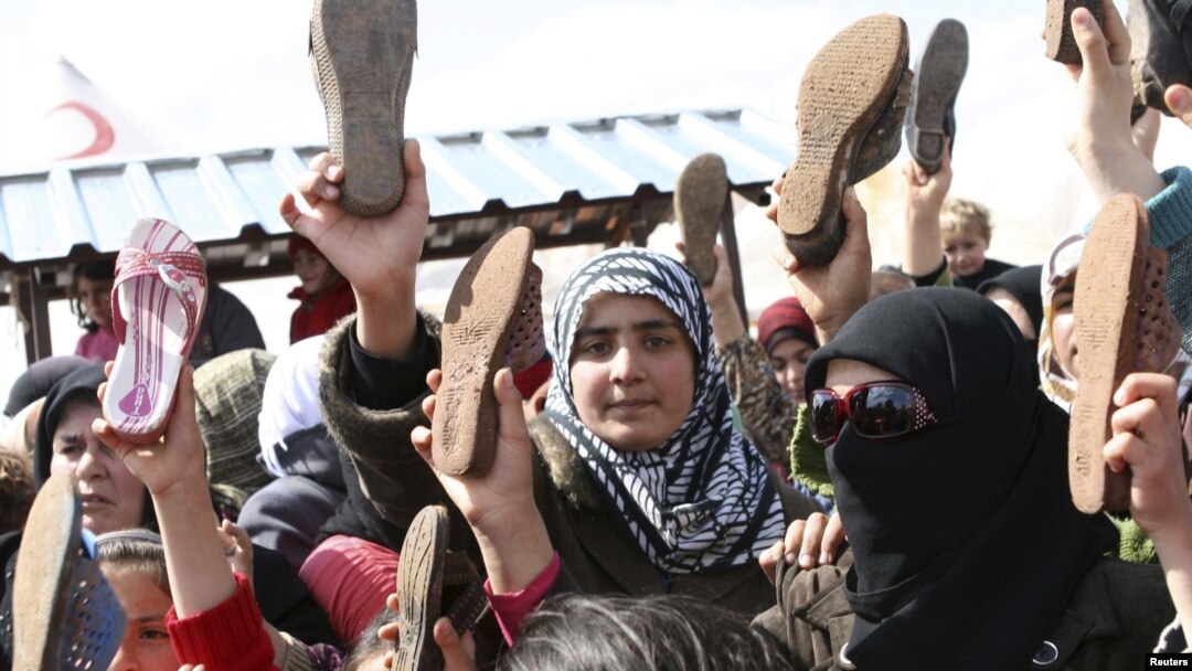 Türkiyədə məskunlaşan suriyalı qaçqınlar ayaqqabılarını çıxarıb Bashar Assad rejiminə etirazlarını bildirirlər. 15 mart 2012