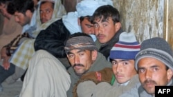 Detained Afghan immigrants sit in a Pakistani security cell in Quetta, just some of the thousands who flee the country every year.