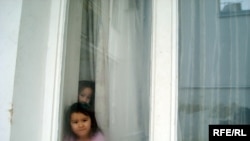 Children of Kazakh asylum seekers peek out of their dormitory in Brno, Czech Republic