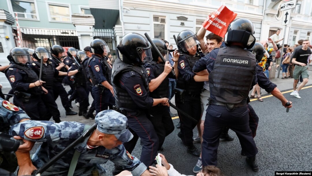 Police and servicemen of the Russian National Guard detain protesters during a rally against planned increases to the pension age in Moscow on September 9.