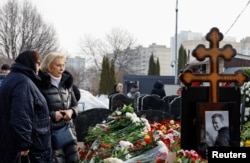Aleksei Navalny's mother, Lyudmila Navalnaya (left), and his mother-in-law, Alla Abrosimova, visit the Russian opposition leader's grave at Borisovskoye Cemetery in Moscow on March 2.