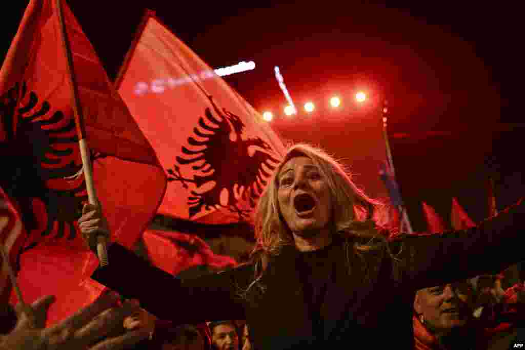 Supporters of the ruling Vetevendosje (Self-determination) party wave Albanian national flags during the party's closing election campaign rally in Pristina on February 7. 