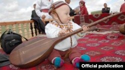 Türkmen çagasynyň dutar çalmaga höwes edýän pursady.