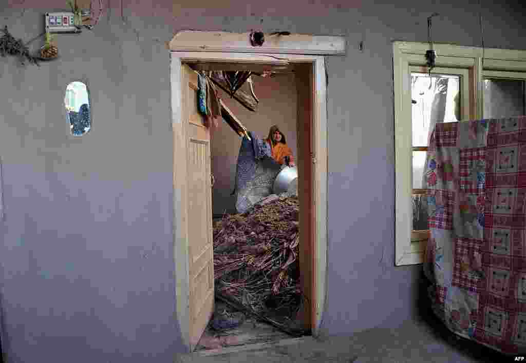 An Afghan woman stands in her home in the village of Charbagh in Nangarhar Province, which was heavily damaged by a powerful earthquake. At least 12 people were killed, more than 100 were injured, and many homes destroyed in the magnitude 5.7 quake. (AFP/Noorullah Shirzada)