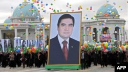 Люди несут портрет президент Туркменистана Гурбангулы Бердымухамедова во время празднования Дня независимости Туркменистана. Ашгабат, 27 октября 2009 года.