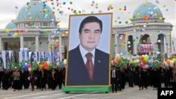 Crowds carry a giant portrait of President Gurbanguly Berdymukhammedov during Turkmen Independence Day celebrations in Ashgabat on October 27, 2009.