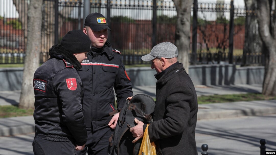 Moldovan police check a man's belongings during an anti-government protest in Chisinau on March 12.