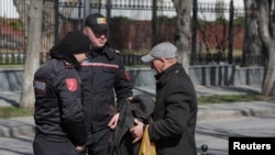 Moldovan police check a man's belongings during an anti-government protest in Chisinau on March 12. 