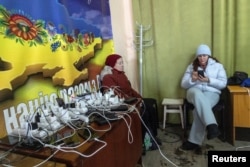 კიევის მცხოვრებლები ტელეფონებს ტენიან და თბებიან „უდრეკობის პუნქტში“. 2026 წლის 10 იანვარი. ფოტო: Reuters-ი