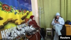 Жени полнат уреди во таканаречениот центар „Точка на нескршливост“, засолниште кое нуди основни услуги и греење за време на прекините на електричната енергија предизвикани од руските напади, 10 јануари 2026 година.