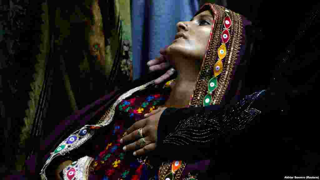 Koonjh, 25 de ani, suferind de febră, așteaptă îngrijiri medicale la Sehwan, Pakistan, 29 septembrie 2022. Țara sa a avut de-a face cu cele mai devastatoare inundații din istoria sa, care au măturat sate întregi afectând mai mult de 33 de milioane de oameni, și generând un val de boli ca provocate de ape, ca malaria și febra denga.&nbsp; (Reuters/Akhtar Soomro)