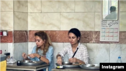 دنیا راد (سمت راست) در یک رستوران تهران در حال خوردن صبحانه.