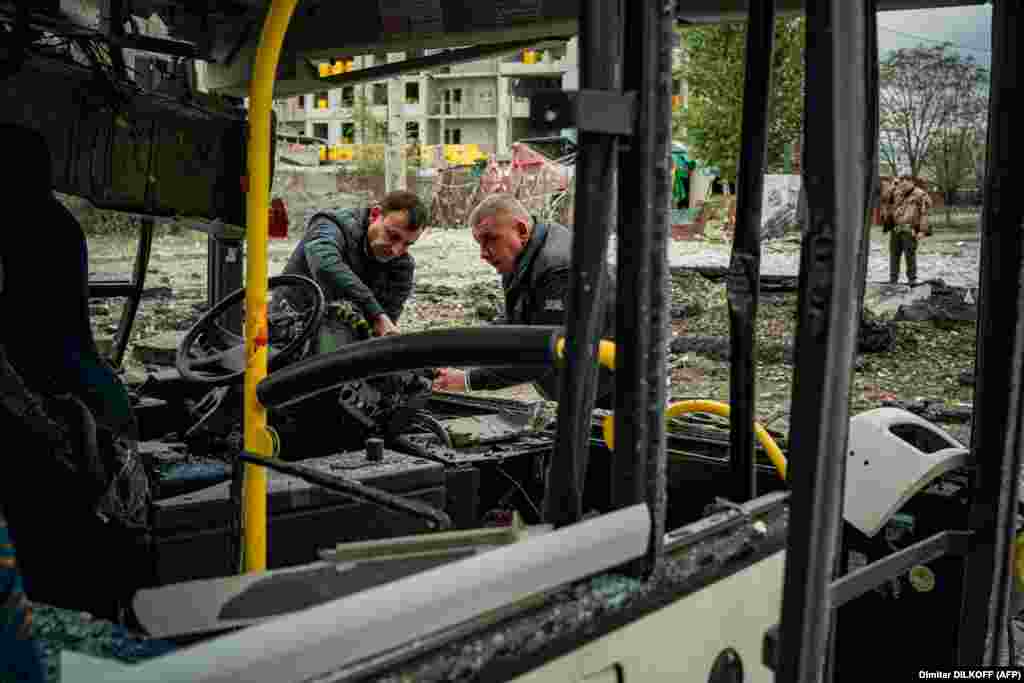 Investigators inspect a bus that was damaged when a missile struck just a few meters in front of it while it was driving.