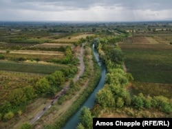 Ididze's herd (bottom left) follow a Soviet-era irrigation canal through the Kakheti region as a distant rainstorm approaches.