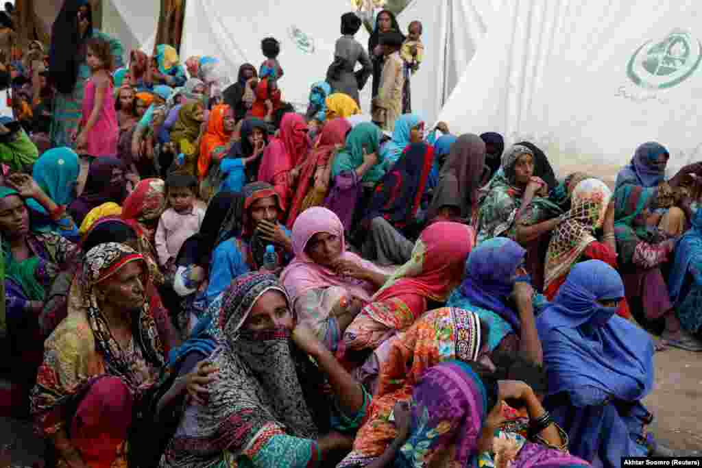 Women displaced because of the floods wait to receive food handouts while taking refuge in a camp in Sehwan. The UN estimates that 1.6 million women of reproductive age, including nearly 130,000 pregnant women, need urgent health services.&nbsp;