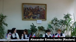 A választási bizottság tagjai szavazókra várnak a referendum idején az úgynevezett Donyecki Népköztársaságban. Donyeck, 2022. szeptember 27. 