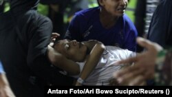 Evakuacija osoba pogođenih suzavcem koji je ispalila interventna policija tokom nereda na stadionu, Malang, Istočna Java, 2. oktobar.