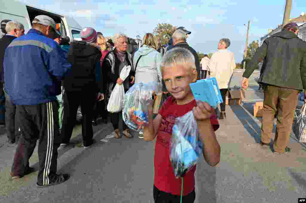 Everyone lends a hand in getting aid packages home in Izyum, the city in the Kharkiv region liberated by Ukrainian troops in early September. It&#39;s estimated that 90 percent of the city is destroyed and its water, gas, and electricity connections all need rebuilding because of heavy Russian shelling. Vans bringing in essentials were quickly surrounded by locals on September 28.