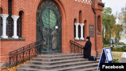 Ксёндз Уладзіслаў Завальнюк моліцца на ганку зачыненага Чырвонага касьцёла, 11 кастрычніка 2022 году.